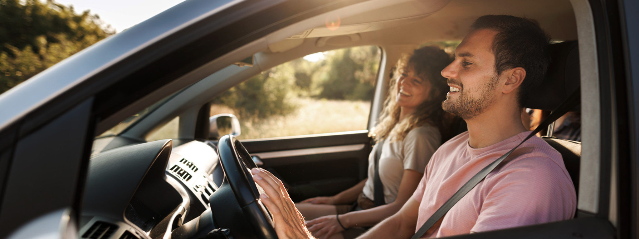 casal no seu carro com um ar feliz