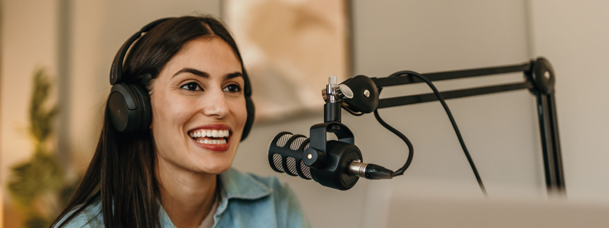 senhora a falar para um microfone e com uns fones