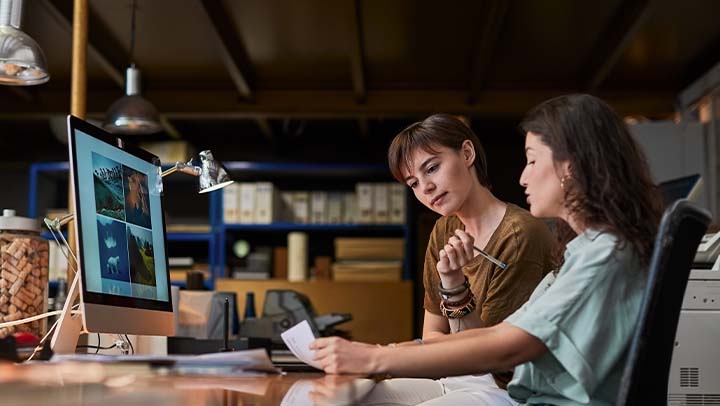 duas mulheres a trabalhar em frente a um computador